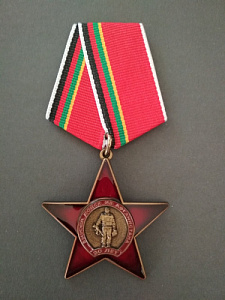 Медаль "30 лет вывода войск из Афганистана". Воин с автоматом на фоне красной звезды.