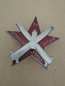 Знак "За отличную боевую подготовку". На красной звезде две пушки и снаряд